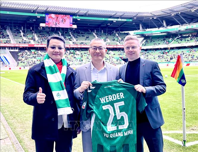 Trưởng phòng Phát triển Kinh doanh và Quốc tế hóa của CLB Werder Bremen (ngoài cùng bên phải) tặng áo CLB cho Đại sứ Vũ Quang Minh (giữa). Ảnh: Phương Hoa - PV TTXVN tại Đức
