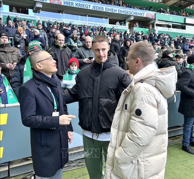 Đại sứ Vũ Quanh Minh (bên trái) giao lưu với đội trưởng CLB Werder Bremen Marco Friedl (giữa) trước trận đấu. Ảnh: Phương Hoa - PV TTXVN tại Đức
