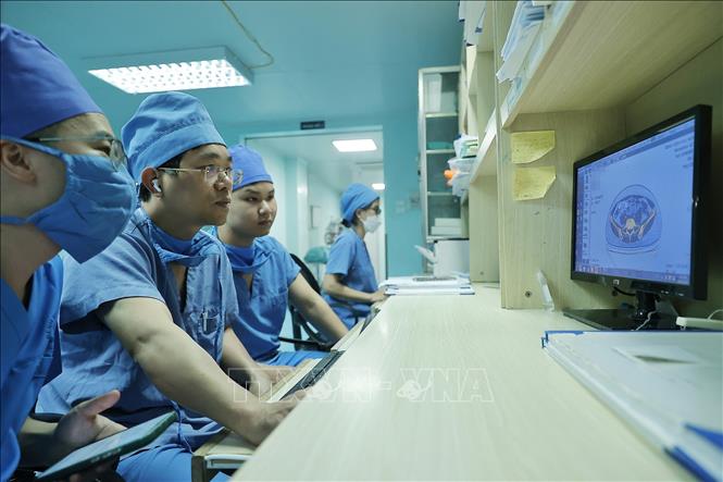 Bác sĩ Long (thứ 2 bên trái) cùng ê kíp xem hồ sơ bệnh án của bệnh nhân trước khi phẫu thuật. Ảnh: Minh Quyết – TTXVN