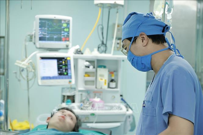 Bác sĩ Long trao đổi với bệnh nhân trước khi phẫu thuật nội soi. Ảnh: Minh Quyết – TTXVN