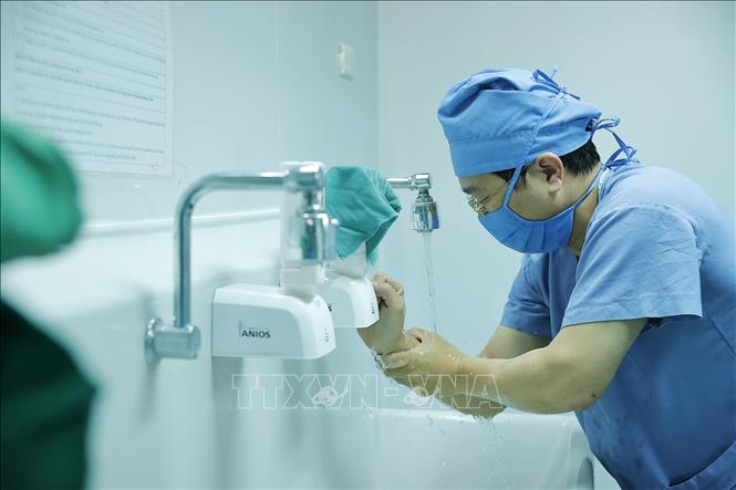 Ngoài công việc quản lý, hằng ngày bác sĩ Long đều có lịch thăm khám và trực tiếp tham gia phẫu thuật cho bệnh nhân nặng. Ảnh: Minh Quyết – TTXVN