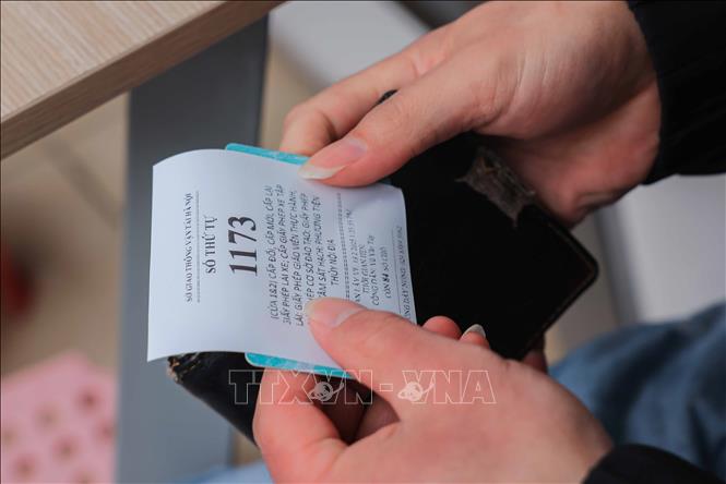 Anh Vũ Văn Tuý (Hà Đông) lấy được số thứ tự làm thủ tục cấp đổi GPLX sau 2 buổi xếp hàng tại số 2 Phùng Hưng (quận Hà Đông). Ảnh: Hoàng Hiếu - TTXVN