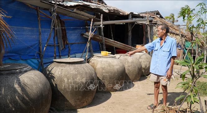 Ông Lê Văn Nghĩa, ấp Bảy Biển, xã Nam Thái A, huyện An Biên, dự trữ 15 lu nước mưa để sử dụng trong mùa khô. Ảnh: Văn Sĩ - TTXVN                                 