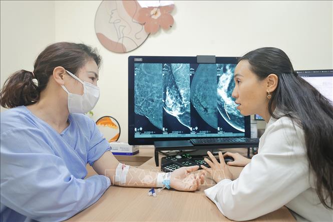 Bác sĩ Bệnh viện đa khoa Tâm Anh tư vấn cho bệnh nhân sau khi chụp X quang 2 mức năng lượng. Ảnh: Minh Quyết - TTXVN