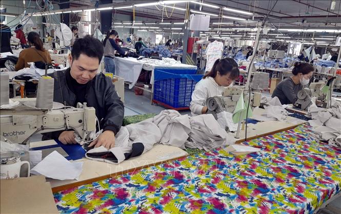 Đảng viên Trần Duy Đô (trái), công nhân Công ty TNHH LongYu Việt Nam (huyện Nam Trực) có nhiều sáng kiến làm lợi cho công ty 150 triệu đồng/năm. Ảnh: TTXVN phát