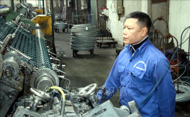 Đảng viên Nguyễn Huy Quang, Công ty cổ phần Dây lưới thép Nam Định (thành phố Nam Định), vận hành máy móc. Ảnh: Nguyễn Lành - TTXVN 