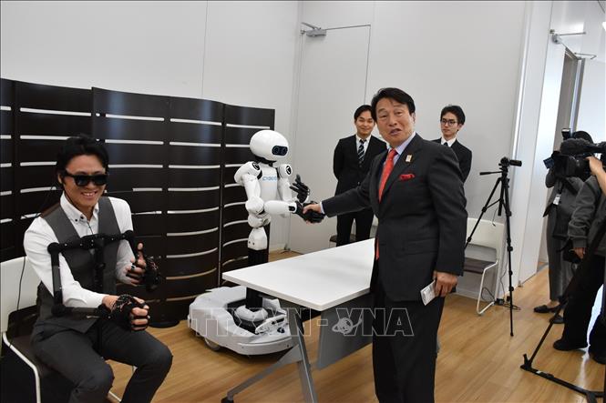 Robot từ xa hoạt động đồng bộ với chuyển động của robot chính trong động tác bắt tay với Tổng giám đốc điều hành Tập đoàn Pason. Ảnh: Nguyễn Tuyến - Pv TTXVN tại Nhật Bản
