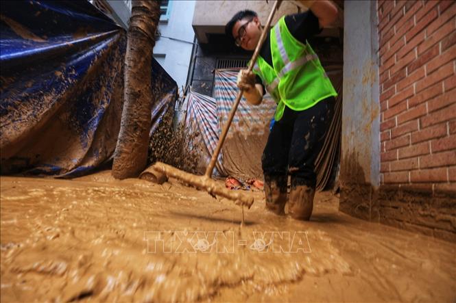 Số lượng bùn nhiều nên công nhân rất vất vả để dọn dẹp (ảnh chụp chiều 22/2). Ảnh: Tuấn Anh - TTXVN 