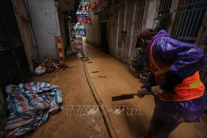 Công nhân dọp dẹp, vệ sinh tại khu vực lượng bùn sau khi được hút hết (ảnh chụp chiều 22/2). Ảnh: Tuấn Anh - TTXVN 