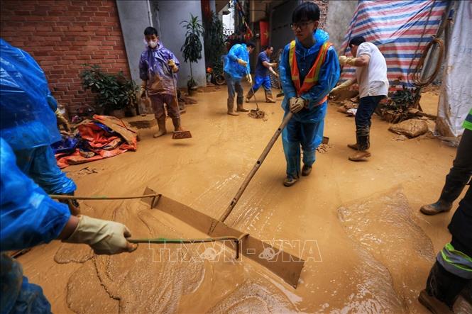 Công nhân vét bùn nhão, tập trung vào khu vực để xe hút bùn đến hút (ảnh chụp chiều 22/2). Ảnh: Tuấn Anh - TTXVN 