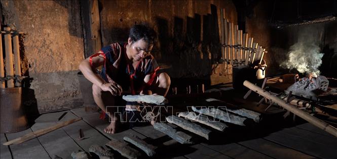 Nghệ nhân ưu tú A Huynh (huyện Sa Thầy, tỉnh Kon Tum) gọt đẽo từng viên đá để cho ra âm thanh tương ứng với các âm trong bộ cồng chiêng của người dân tộc thiểu số. Ảnh: Khoa Chương - TTXVN