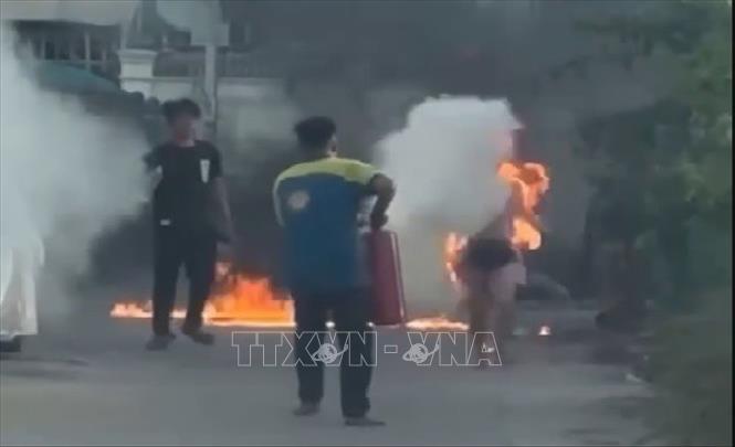 Người dân dùng bình chữa cháy cứu nạn nhân. Ảnh: TTXVN phát