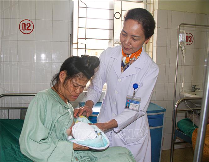 Thạc sĩ, bác sĩ Ngô Thị Nhung (Trưởng Khoa sản, Bệnh viện Đa khoa tỉnh Điện Biên) chăm sóc mẹ và bé sau sinh. Ảnh: Phan Quân - TTXVN