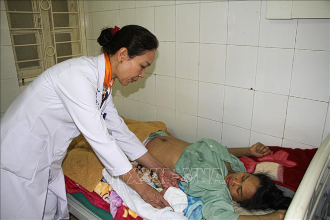 Thạc sĩ, bác sĩ Ngô Thị Nhung (Trưởng Khoa sản, Bệnh viện Đa khoa tỉnh Điện Biên) chăm sóc mẹ và bé sau sinh. Ảnh: Phan Quân - TTXVN