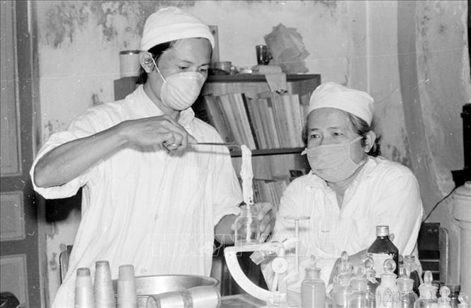 Sau ngày đất nước thống nhất, ngành Y tế đã có những bước phát triển vượt bậc và đạt được những thành tựu quan trọng trong sự nghiệp chăm sóc và bảo vệ sức khỏe nhân dân. Trong ảnh: Kỹ thuật viên Phạm Nguyên Quyền (Học viện Y Huế) nghiên cứu thành công chỉ tự tiêu từ nguyên liệu địa phương (ruột lợn, da súc vật, chỉ tơ tằm...) để sử dụng trong phẫu thuật (1984). Ảnh: Thu Hoài - TTXVN