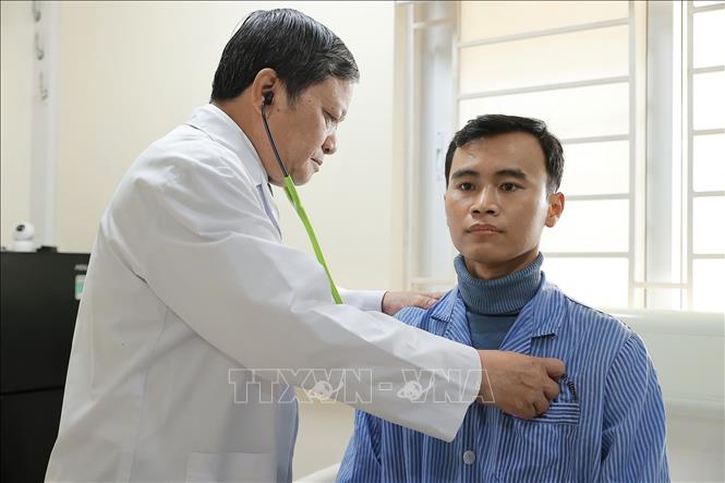 TTƯT.TS.BS. Đinh Văn Lượng thăm khám cho bệnh nhân Đặng Thái Mạnh (28 tuổi, ở Phú Thọ Hòa, Tân Phú, TPHCM), anh Mạnh đã được cùng gia đình đón cái Tết Ất Tỵ hồi sinh mà không phải thở oxy hàng ngày như 6 tháng trước. Ảnh: Minh Quyết – TTXVN