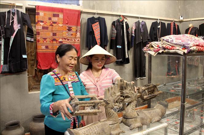 Bà Sầm Thị Bích, chủ homestay Bích Trang, bản Hoa Tiến, xã Châu Tiến (Quỳ Châu, Nghệ An) giới thiệu các hiện vật phản ánh đời sống văn hóa dân tộc Thái cho du khách. Ảnh: Văn Tý - TTXVN 