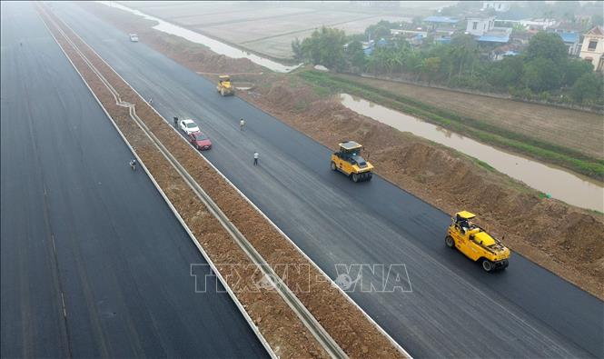 Dự án đường bộ mới Nam Định - Lạc Quần - Đường bộ ven biển đoạn qua huyện Nam Trực đang được khẩn trương thảm mặt đường. Ảnh: Quốc Khánh - TTXVN