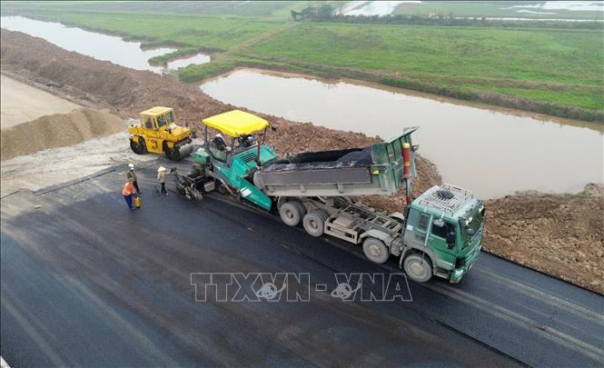 Tuyến đường đoạn qua huyện Nam Trực đang được khẩn trương thảm mặt đường. Ảnh: Quốc Khánh - TTXVN