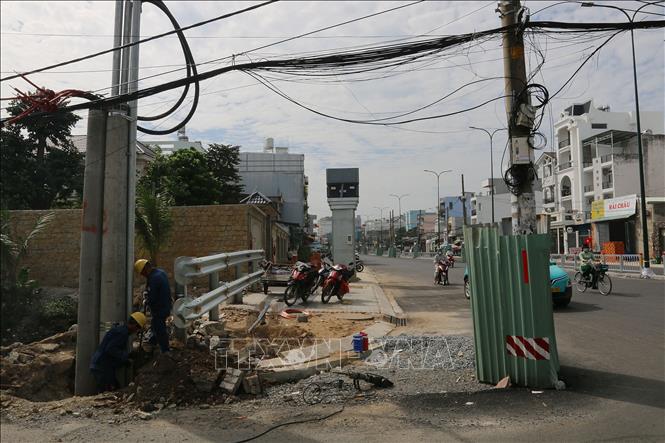 Các đơn vị nhà thầu gấp rút thi công trồng trụ điện mới trên tuyến đường Dương Quảng Hàm (quận Gò Vấp, TP. Hồ Chí Minh). Ảnh: Thanh Vũ-TTXVN
