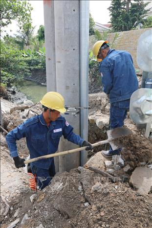 Các nhà thầu đang gấp rút thi công trồng trụ điện mới thay thế trụ điện cũ trên tuyến đường Dương Quảng Hàm (quận Gò Vấp, TP. Hồ Chí Minh). Ảnh: Thanh Vũ-TTXVN
