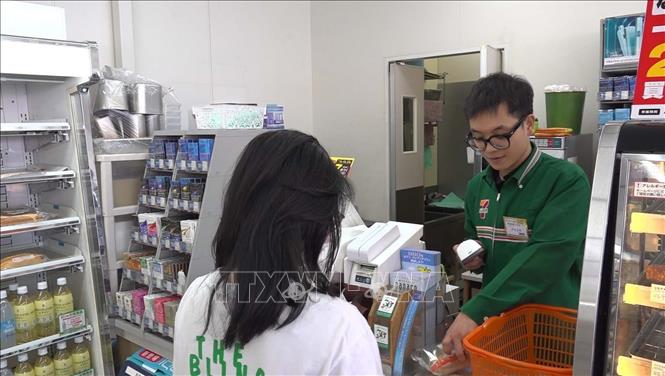 Nhân viên cửa hàng tiện lợi 7-Eleven đang thanh toán cho khách hàng. Ảnh: Nguyễn Tuyến - PV TTXVN tại Nhật Bản