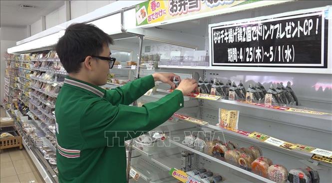 Nhân viên cửa hàng tiện lợi 7-Eleven đang sắp xếp hàng hóa lên kệ. Ảnh: Nguyễn Tuyến - PV TTXVN tại Nhật Bản
