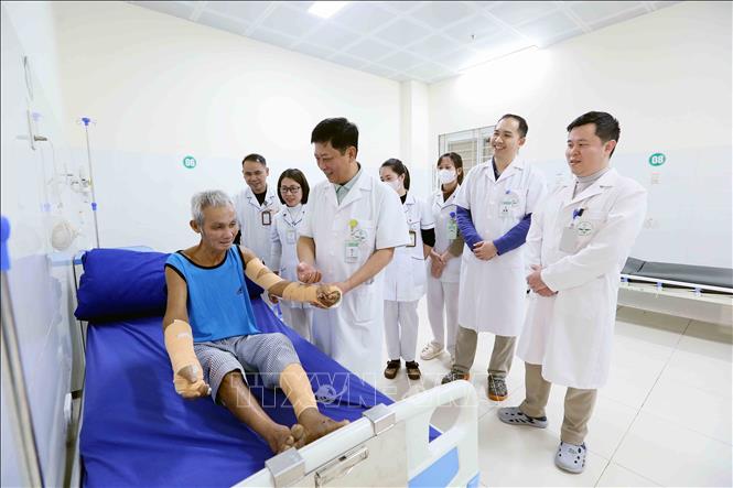 Tiến sĩ, bác sĩ Trần Hồng Vinh và đồng nghiệp thăm khám cho bệnh nhân. Ảnh: Quang Quyết - TTXVN