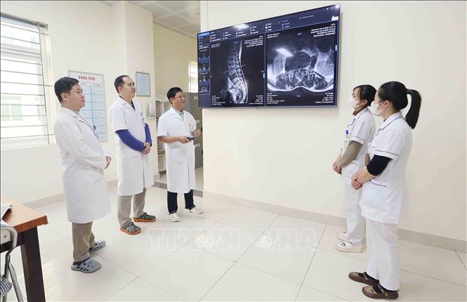 Tiến sĩ, bác sĩ Trần Hồng Vinh (giữa) và đồng nghiệp chẩn đoán bệnh qua hình ảnh. Ảnh: Quang Quyết - TTXVN