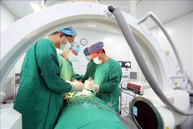 Tiến sĩ, bác sĩ Trần Hồng Vinh (bên phải) và đồng nghiệp tiến hành phẫu thuật cho bệnh nhân. Ảnh: Quang Quyết - TTXVN