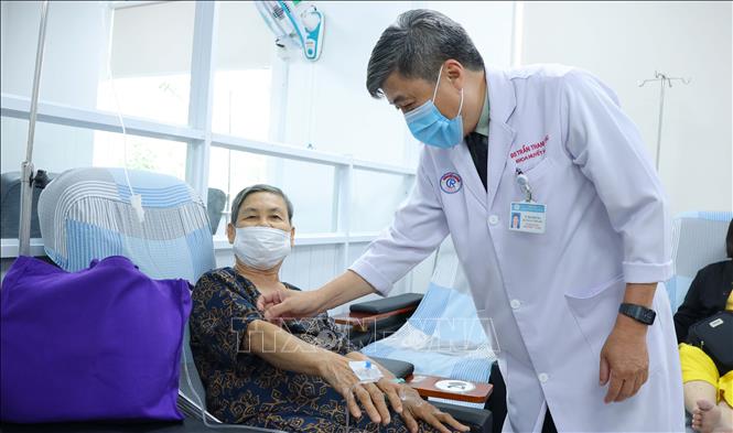 TS.BS Trần Thanh Tùng thăm hỏi, kiểm tra việc điều trị của người bệnh. Ảnh: Đinh Hằng - TTXVN