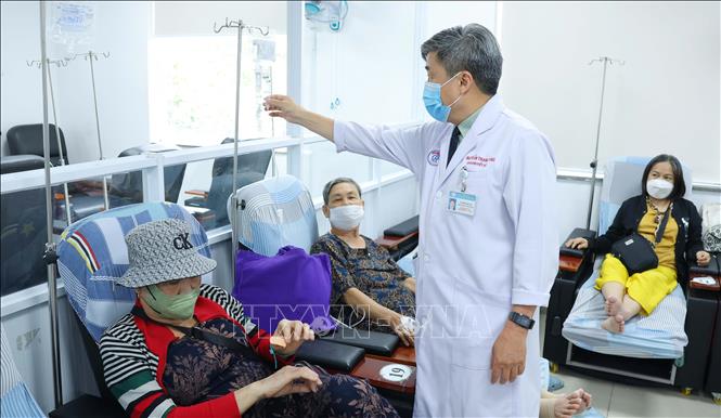 TS.BS Trần Thanh Tùng thăm hỏi, kiểm tra việc điều trị của người bệnh. Ảnh: Đinh Hằng - TTXVN