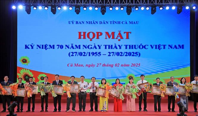 Phó Chủ tịch UBND tỉnh Nguyễn Minh Luân, Trưởng Ban tuyên giáo Tỉnh ủy và Dân vận Hồ Trung Việt thừa ủy quyền của Thủ tướng Chính phủ tặng Bằng khen cho tập thể Phòng Điều dưỡng Bệnh viện Đa khoa Cà Mau và 15 cá nhân. Ảnh: Huỳnh Anh - TTXVN