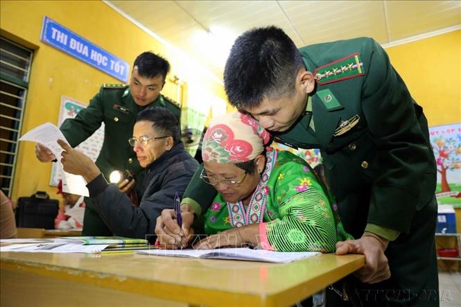 Cùng với thầy cô giáo được phân công đứng lớp, các chiến sĩ đồn Biên phòng ở Mường Nhé (BĐBP tỉnh Điện Biên) tham gia hỗ trợ các học viên để việc học xóa mù chữ được hiệu quả hơn. Ảnh: Trung Kiên – TTXVN