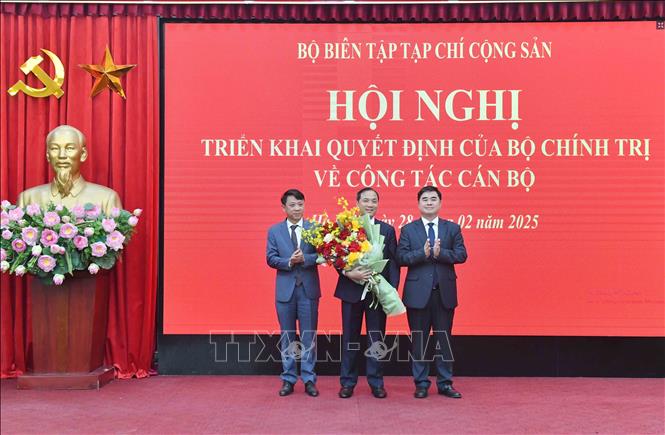 Lãnh đạo Tạp chí Cộng sản tặng hoa chúc mừng đồng chí Hoàng Trung Dũng. Ảnh: TTXVN