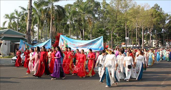 Trong trang phục áo dài truyền thống, cán bộ và hội viên phụ nữ Đồng Tháp diễu hành qua một số tuyến đường ở thành phố Cao Lãnh. Ảnh: Nhựt An - TTXVN