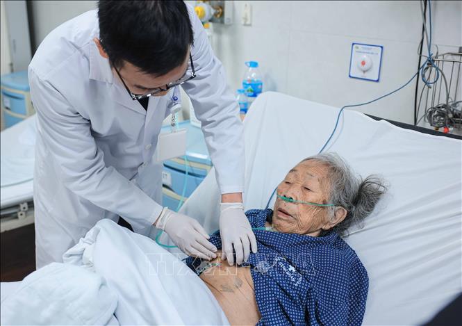 Ths.BS Vũ Khang Ninh - Phó trưởng Khoa Cấp cứu, Trưởng Bộ phận cấp cứu ngoại Bệnh viện Thanh Nhàn kiểm tra vết mổ bà Dương Thị Liễn (90 tuổi, Sóc Sơn, Hà Nội). Ảnh: Hoàng Hiếu - TTXVN
