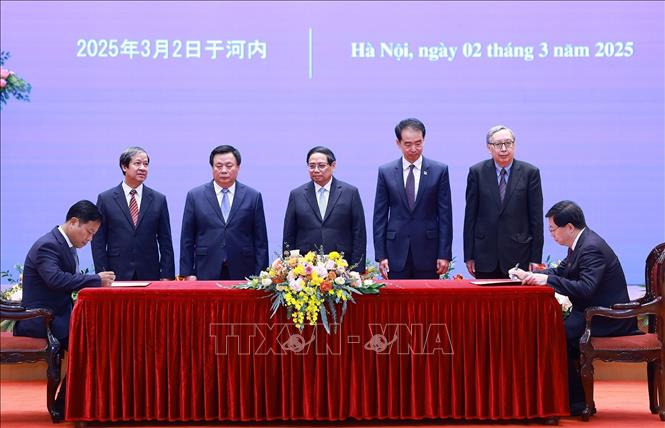 Thủ tướng Phạm Minh Chính chứng kiến ký văn kiện hợp tác giáo dục giữa Đại học Quốc gia Hà Nội và Đại học Thanh Hoa, Trung Quốc. Ảnh: Dương Giang-TTXVN
