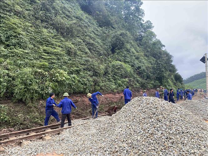 Công nhân tập trung sửa chữa, khắc phục hạ tầng giao thông. Ảnh: Hữu Quyết - TTXVN