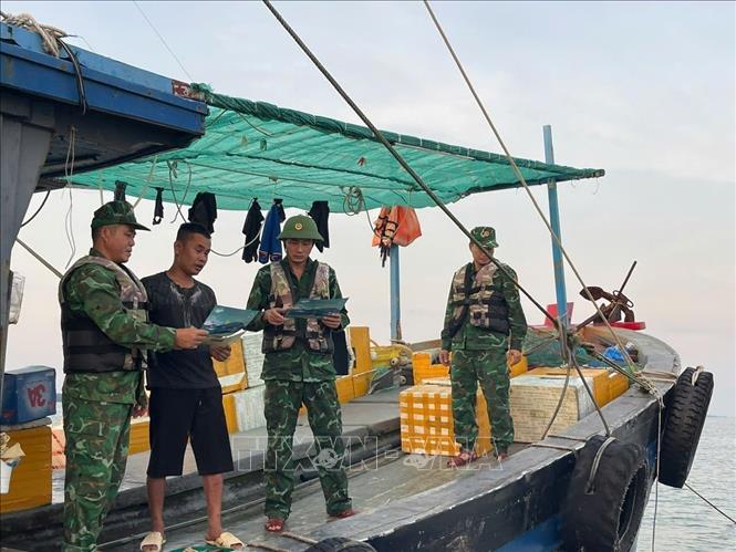 Cán bộ, chiến sĩ Đồn Biên phòng Trà Cổ tuyên truyền pháp luật cho ngư dân. Ảnh: TTXVN phát