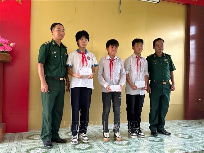 Đồn Biên phòng Trà Cổ khen thưởng cho các học sinh có hoàn cảnh khó khăn vươn lên trong học tập. Ảnh: TTXVN phát