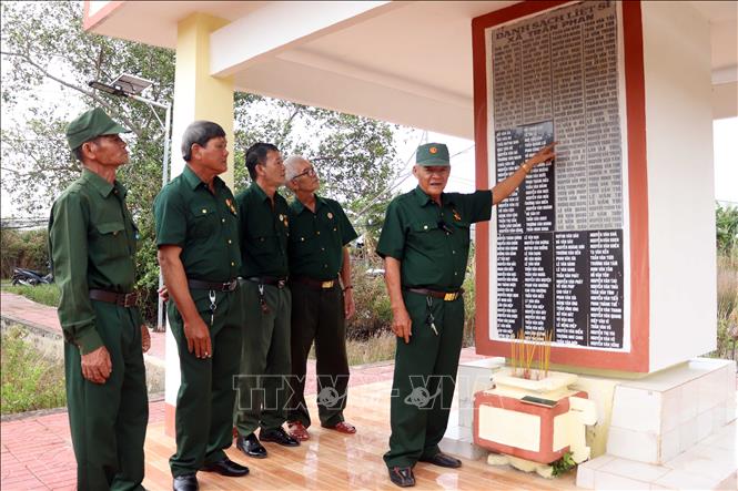 Các cựu chiến binh thăm nhà bia ghi danh các Anh hùng liệt sĩ xã Trần Phán, huyện Đầm Dơi. Ảnh: Kim Há - TTXVN