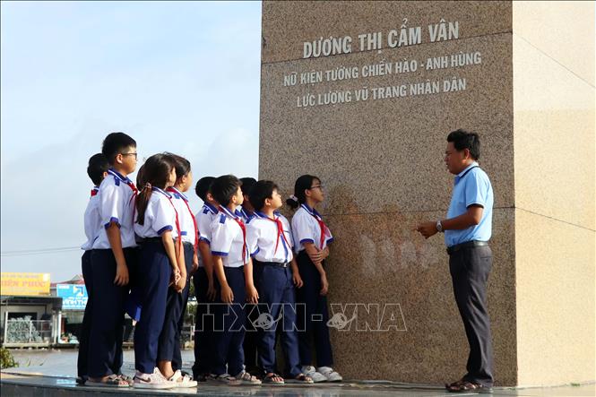 Thầy và trò Trường THCS Dương Thị Cẩm Vân sinh hoạt giáo dục truyền thống cách mạng tại Tượng đài Anh hùng lực lượng vũ trang nhân dân Dương Thị Cẩm Vân (thị trấn Đầm Dơi, huyện Đầm Dơi). Ảnh: Kim Há – TTXVN