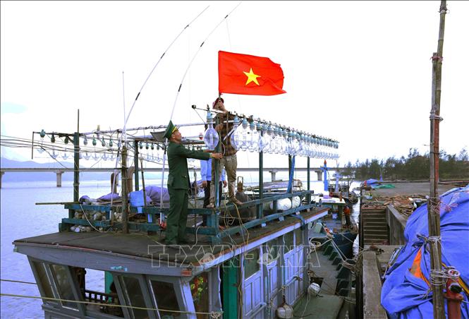 BĐBP thành phố Huế tặng cờ Tổ quốc cho chủ tàu cá Lê Văn Thanh (thôn Đông Dương, xã Vinh Hiền, huyện Phú Lộc). Ảnh: Vũ Sinh - TTXVN