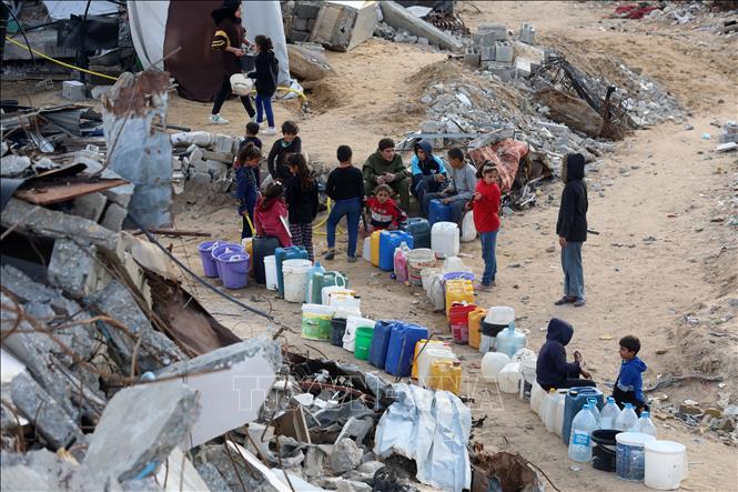 Người dân Palestine bên đống đổ nát của những ngôi nhà bị sập do chiến sự tại Beit Hanoun, Dải Gaza, ngày 19/2/2025. Ảnh: THX/TTXVN