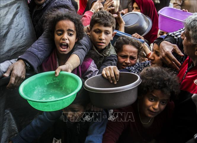 Người dân nhận thức ăn cứu trợ tại thành phố Gaza. Ảnh: THX/TTXVN