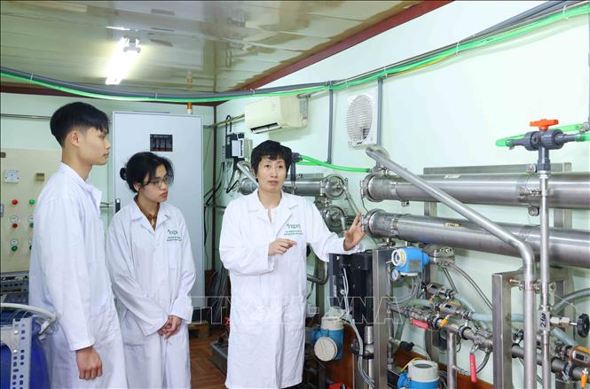 PGS.TS Nguyễn Minh Tân hướng dẫn sinh viên về hệ thống phân tách lọc nano cao áp dùng trong tinh chất các hợp thức thiên. Ảnh: Phương Hoa - TTXVN