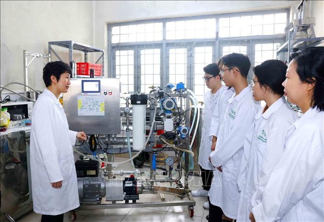 PGS.TS Nguyễn Minh Tân hướng dẫn sinh viên về hệ thống xử lý nước thải bằng công nghệ màng. Ảnh: Phương Hoa - TTXVN