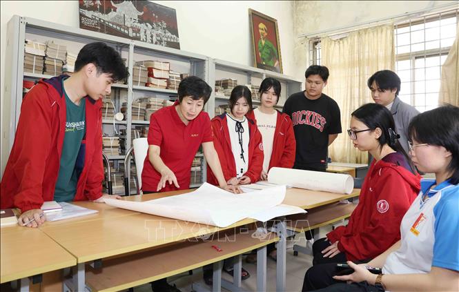 PGS.TS Nguyễn Minh Tân hướng dẫn sinh viên làm đồ án nghiên cứu khoa học. Ảnh: Phương Hoa - TTXVN