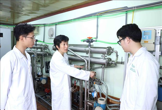 PGS.TS Nguyễn Minh Tân hướng dẫn sinh viên về hệ thống phân tách lọc nano cao áp dùng trong tinh chất các hợp thức thiên. Ảnh: Phương Hoa - TTXVN